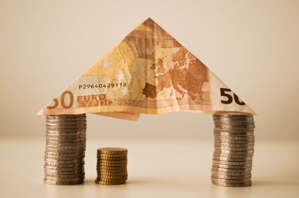 Casa hecha con billetes y monedas de euro, símbolo a las ayudas económicas a la vivienda