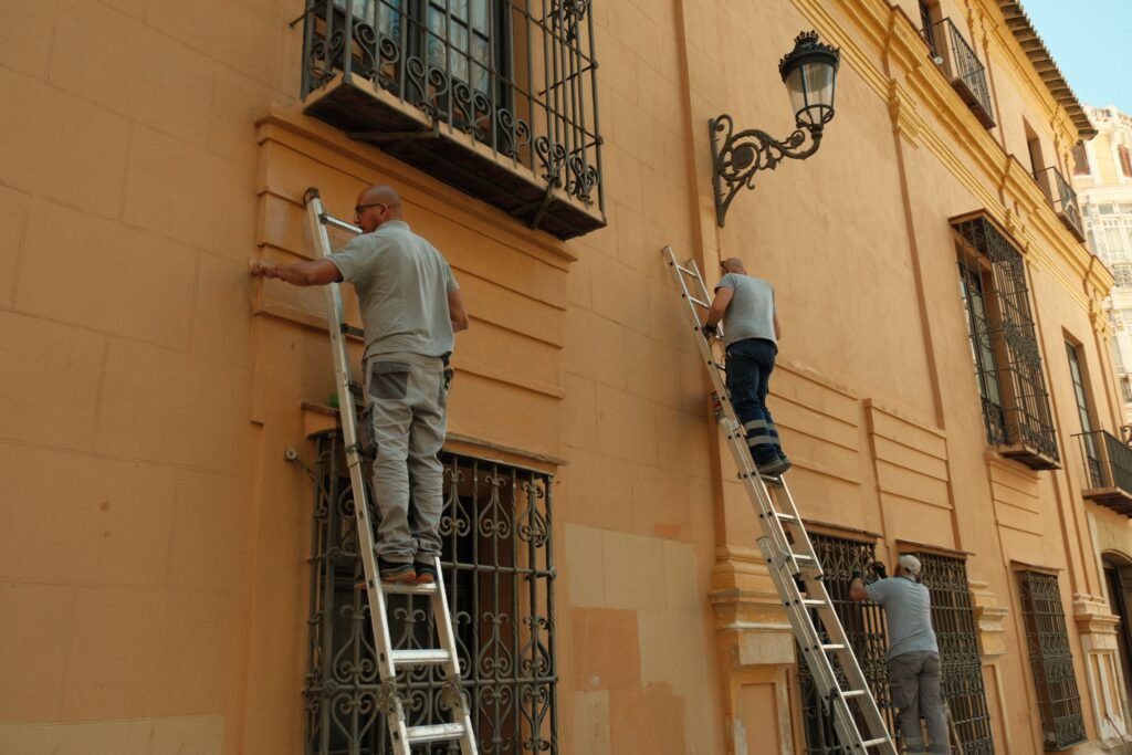 Operarios realizando trabajos de rehabilitación en la fachada de un edificio en España