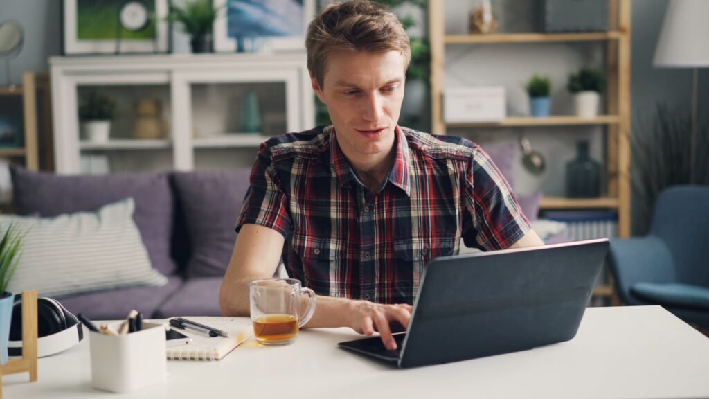 Hombre completando un trámite online desde su portátil en casa