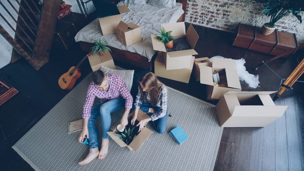 Pareja joven organizando su nuevo piso de alquiler