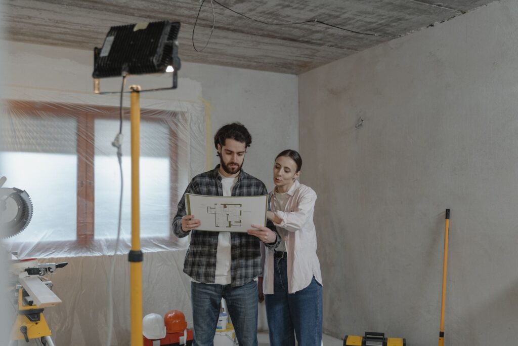 Pareja revisando planos de rehabilitación energética en una vivienda en obras