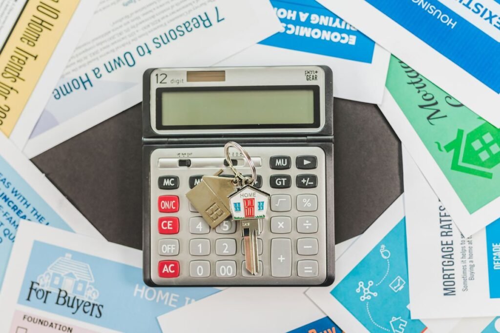 Calculadora con llaves sobre folletos inmobiliarios