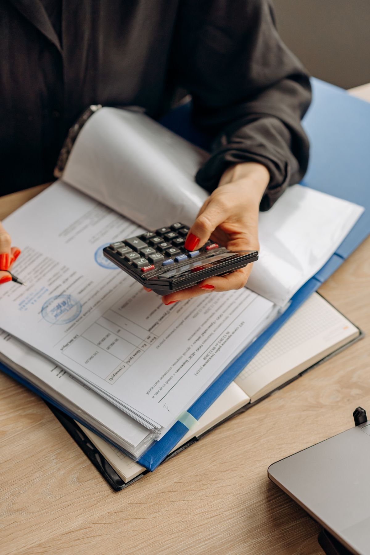 Persona con una calculadora revisando documentos