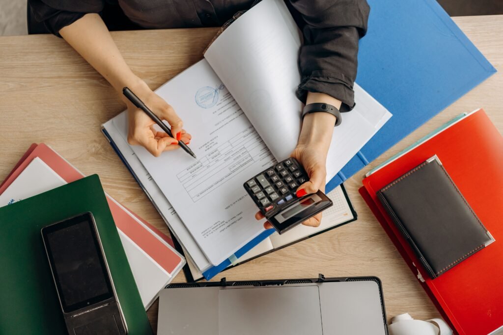 Persona con calculadora revisando documentos para aplicar la deducción del alquiler en el IRPF