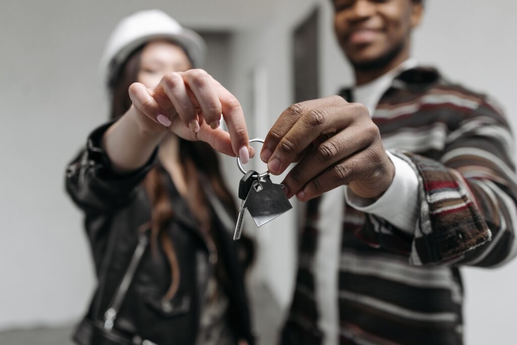 Pareja joven sujetando las llaves de su primera vivienda