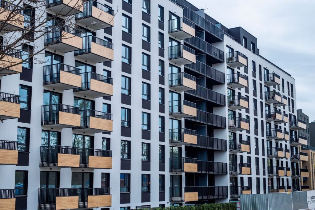 Edificio residencial moderno de obra nueva con balcones de madera y barandillas negras