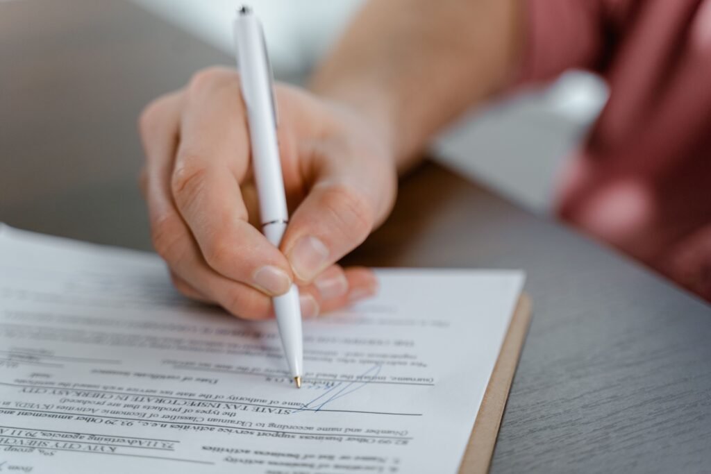Mano firmando la solicitud de prórroga de un contrato de alquiler